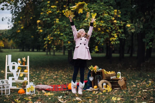 Girl playing with fallen leaves — Stock Photo, Image