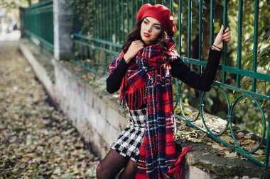 Genç kadın sonbahar parkında yürüyor.