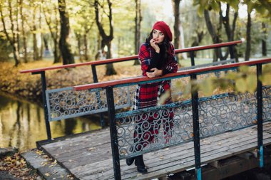 Genç kadın sonbahar parkında yürüyor.