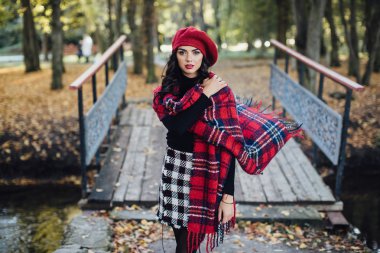 Genç kadın sonbahar parkında yürüyor.