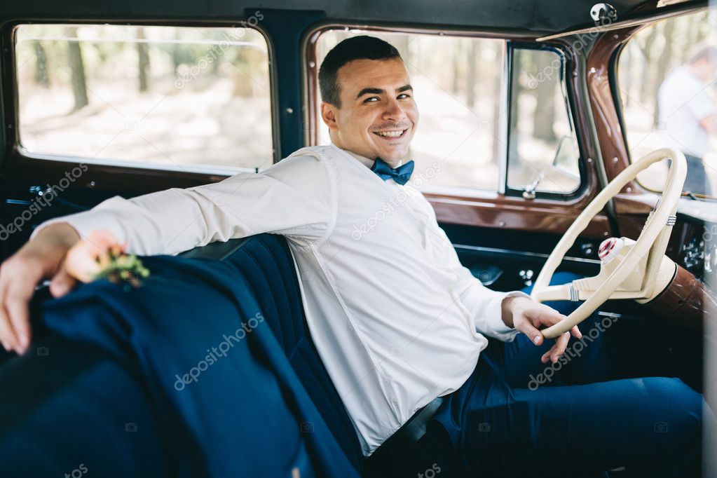 handsome groom in car