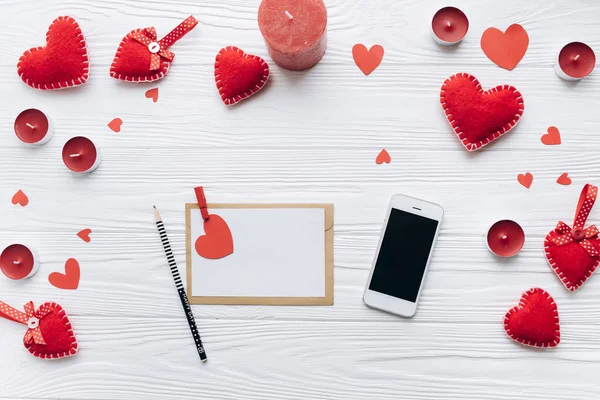 Любовное письмо с красными сердцами и телефоном — стоковое фото