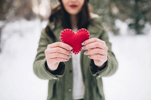 Menina segurando coração no inverno natureza — Fotografia de Stock