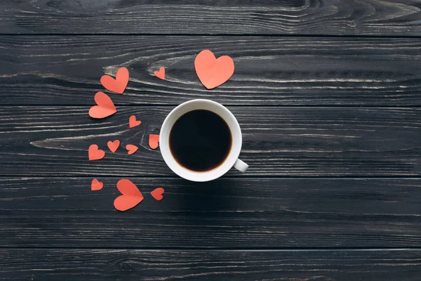 Corações de papel vermelho e uma xícara de café — Fotografia de Stock