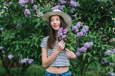 Kız Eflatun çiçekler içinde ayakta