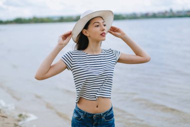 Kumsalda şapkalı bir kadın