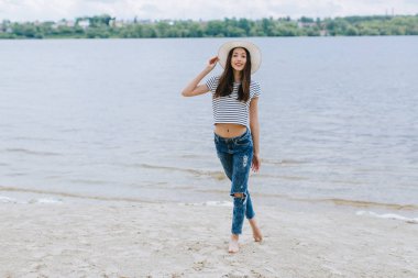 Kumsalda şapkalı bir kadın