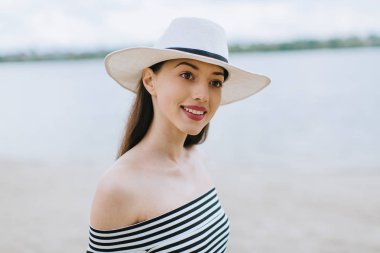 Kumsalda şapkalı bir kadın