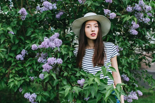 Menina de pé em flor lilás — Fotografia de Stock