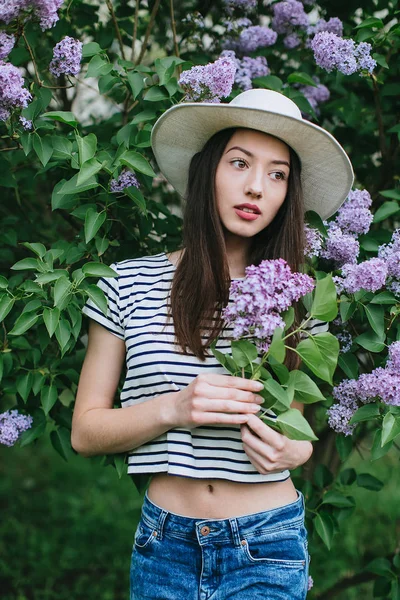 Menina de pé em flor lilás — Fotografia de Stock