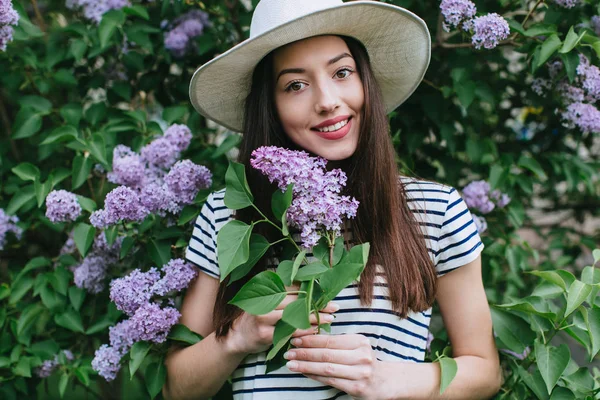 Menina de pé em flor lilás — Fotografia de Stock