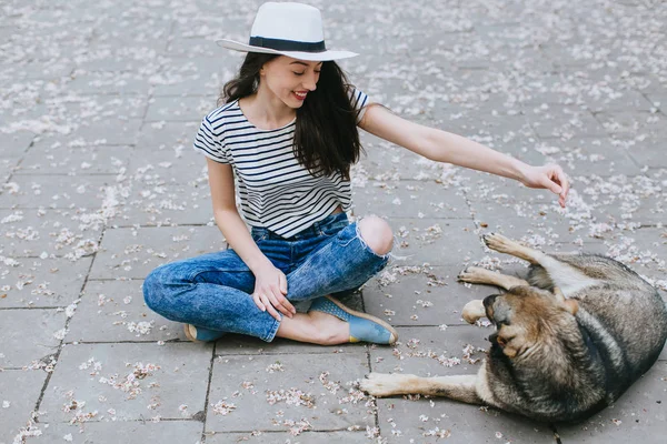 Girl plays with homeless dog — Stock Photo, Image