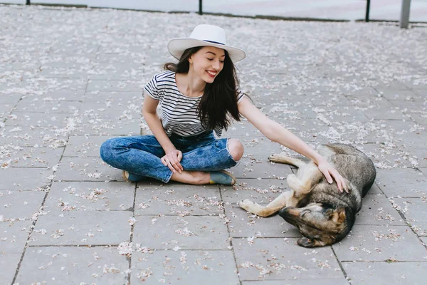 Girl plays with homeless dog — Stock Photo, Image