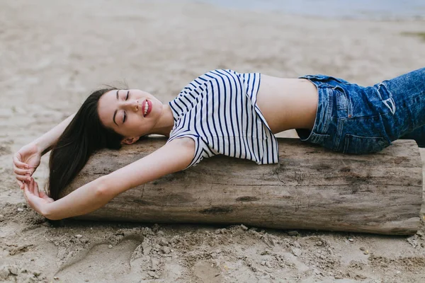 Jonge vrouw liggend op de houten been — Stockfoto