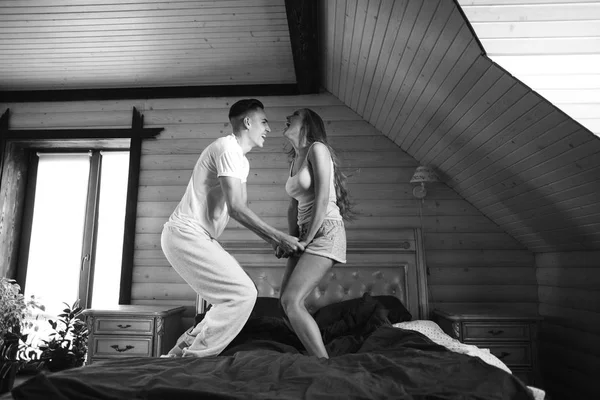 Casal pulando na cama — Fotografia de Stock