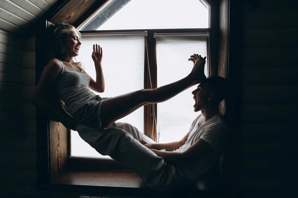 Jovem casal perto da janela — Fotografia de Stock