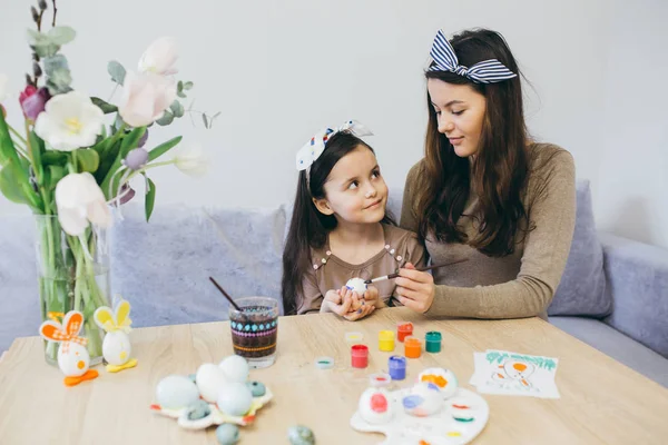 Mãe e filha bonito pintar ovos — Fotografia de Stock