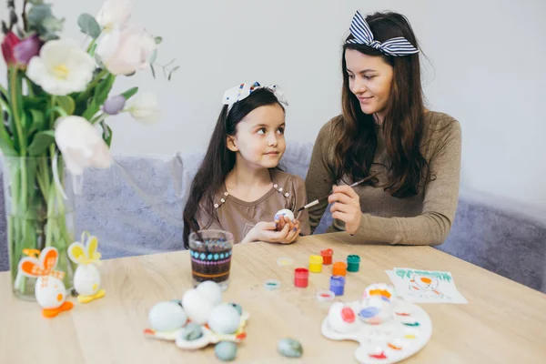 Mãe e filha bonito pintar ovos — Fotografia de Stock