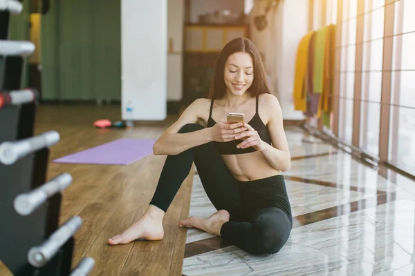 Fitness Girl using mobile phone — Stock Photo, Image