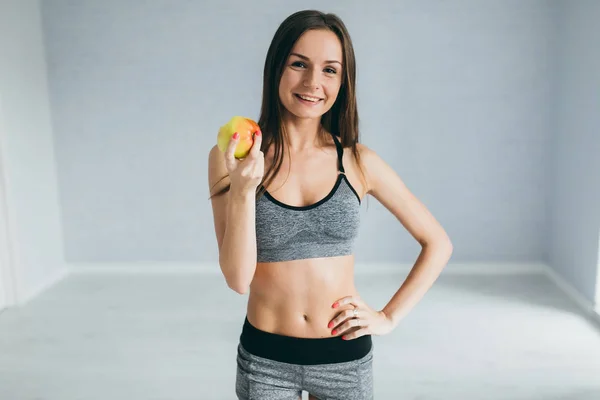 Fitness girl holding apple — Stock Photo, Image