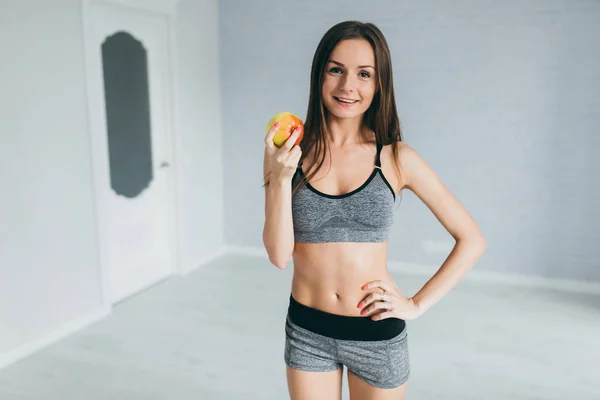 Fitness girl holding apple — Stock Photo, Image