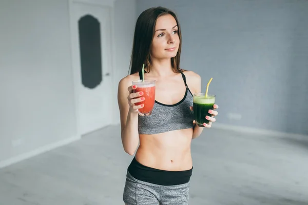 Fitness girl holding cocktails — Stock Photo, Image