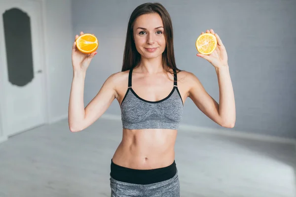 Γυμναστήριο κορίτσι εκμετάλλευση πορτοκαλί φέτες — Φωτογραφία Αρχείου