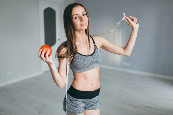 Chica con medida y manzana — Foto de Stock