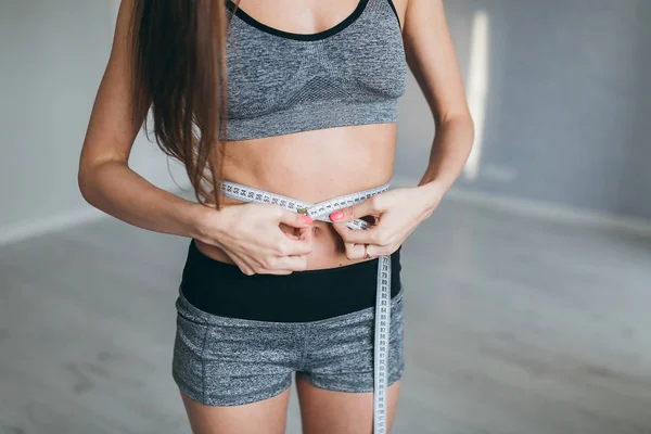 Girl measures waist after training — Stock Photo, Image