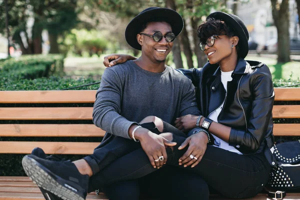 african couple hugging on bench