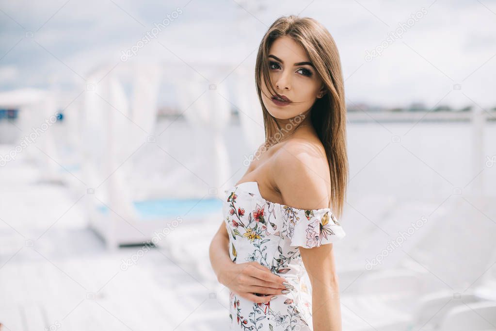 woman in stylish dress on beach terrace