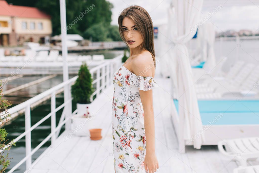woman in stylish dress on beach terrace