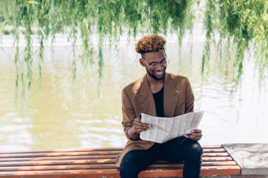 Gölün yanında bir gazete ile bir ceketli adamı