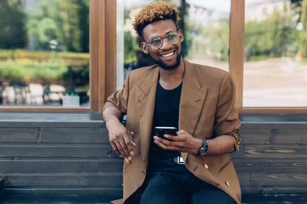 Man i en jacka med telefon i city — Stockfoto