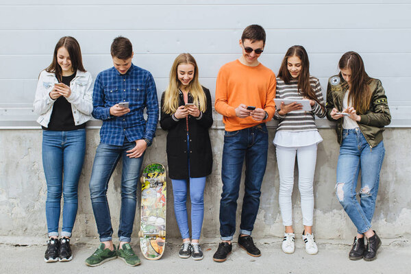 Группа подростков на улице с мобильными телефонами
