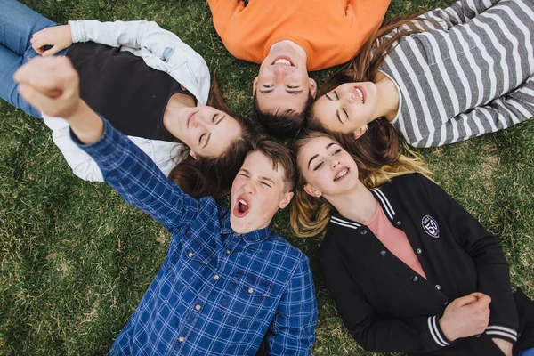 Adolescentes deitados na grama em um verão — Fotografia de Stock