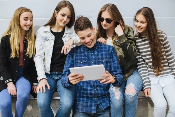 Adolescentes sonrientes pasando el rato afuera con la tableta —  Fotos de Stock