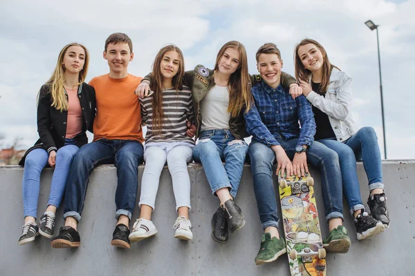 Smiling teenagers with skateboard hanging out outside — Stock Photo, Image