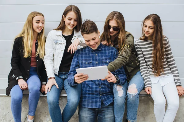 Adolescentes sonrientes pasando el rato afuera con la tableta —  Fotos de Stock