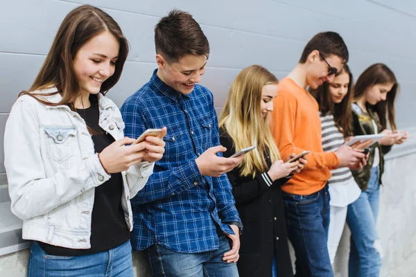 Grupo de adolescentes ao ar livre com telefones celulares — Fotografia de Stock