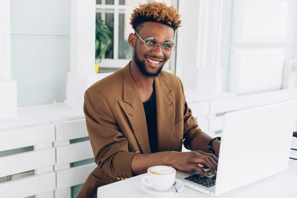 Man som arbetar på laptop och dricker kaffe — Stockfoto