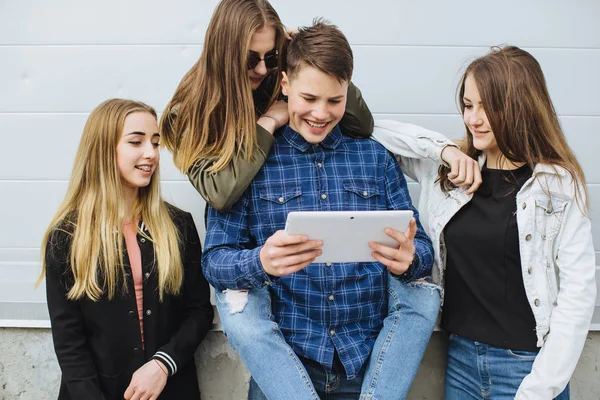 Smiling teenagers hanging out outside with tablet — Stock Photo, Image