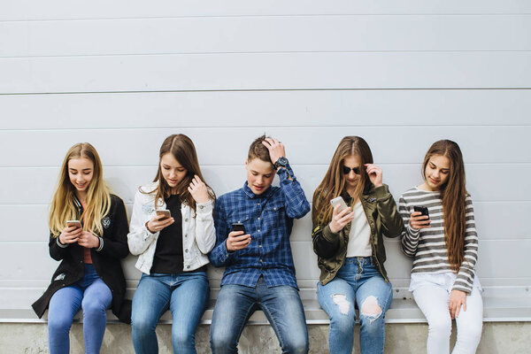 Group of teenagers outdoors with mobile phones