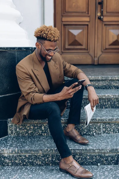 Telefon ve şehir gazetesi ile bir ceketli adamı