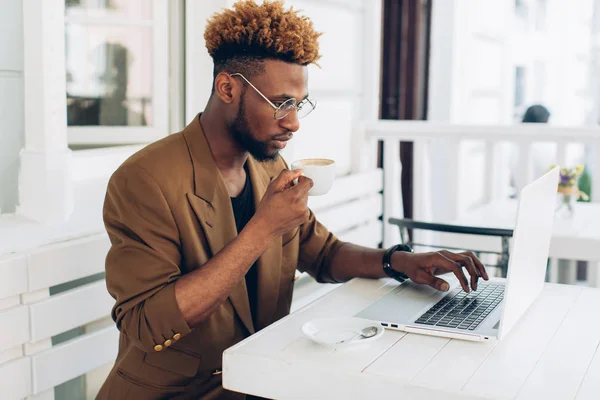 Man som arbetar på laptop och dricker kaffe — Stockfoto