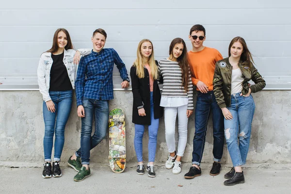 Adolescenti sorridenti con skateboard appeso fuori — Foto Stock