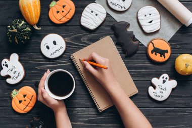 Cadılar Bayramı için gingerbread ile masada oturan kız 