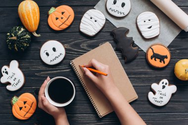 Cadılar Bayramı için gingerbread ile masada oturan kız 