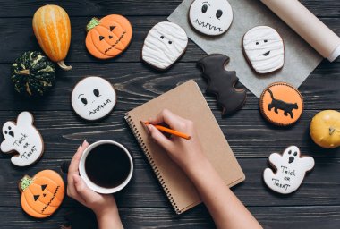 Cadılar Bayramı için gingerbread ile masada oturan kız 