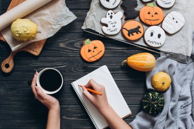Cadılar Bayramı için gingerbread ile masada oturan kız 